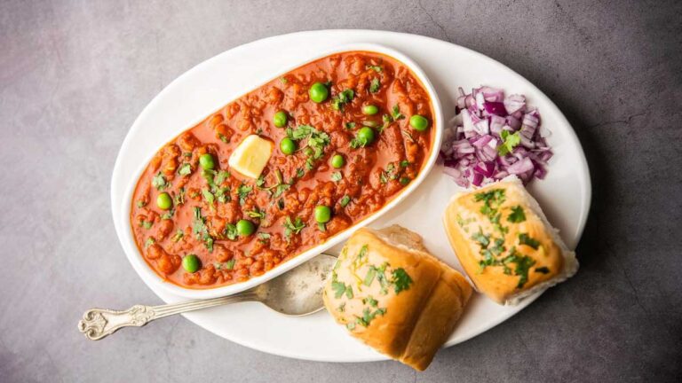 Cheese pav bhaji topped with grated cheese and served with buttery pav bread.