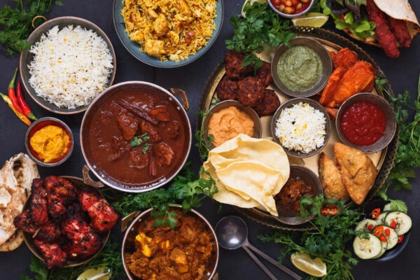 An Indian food spread with tandoori chicken, curries, biryani, samosas, and naan at Punjabi Zaaika restaurant.