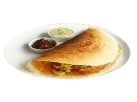 Crispy golden masala dosa folded on a white plate, served with coconut chutney and tomato sambar.