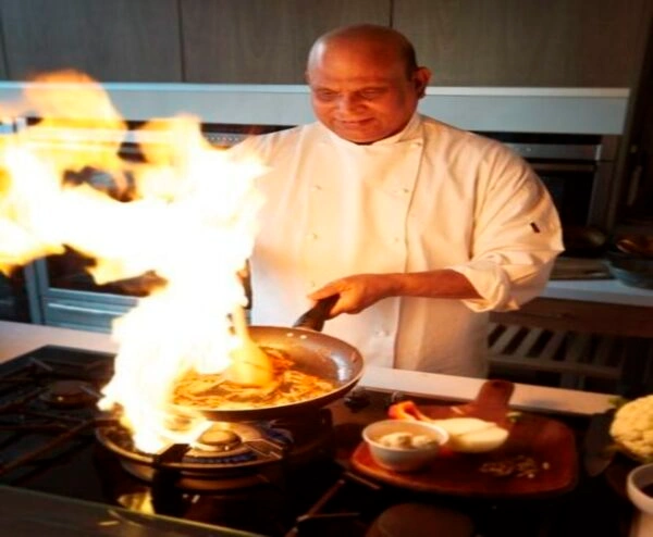 Chef preparing authentic Indian cuisine in the Punjabi Zaaika kitchen using traditional cooking techniques.