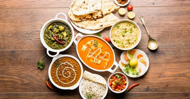Traditional Indian meal with butter chicken, dal, naan, rice, and saag served at an Indian restaurant in Vietnam.